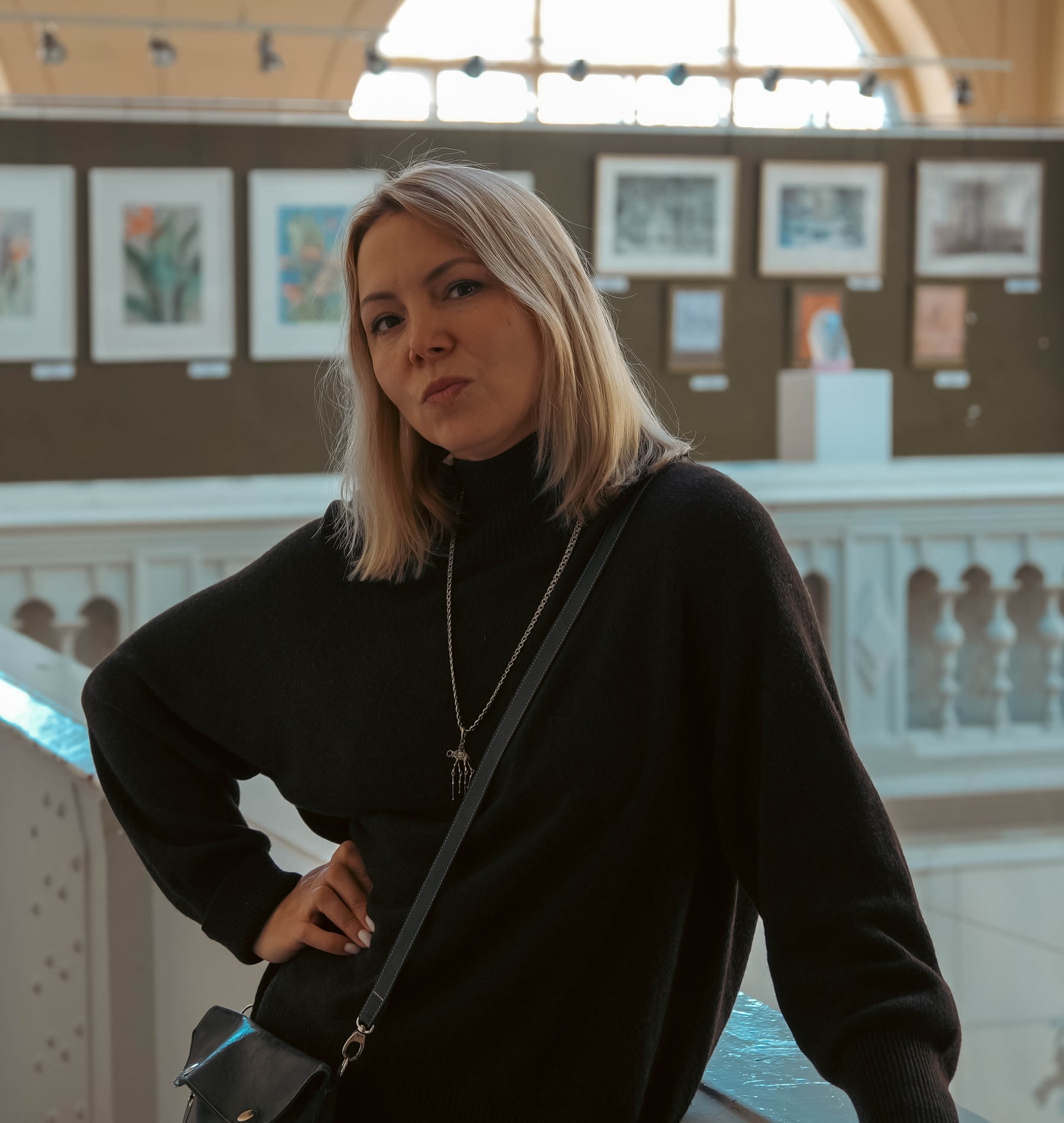 Юлия Барыева в выставочном зале, на фоне произведений искусства.